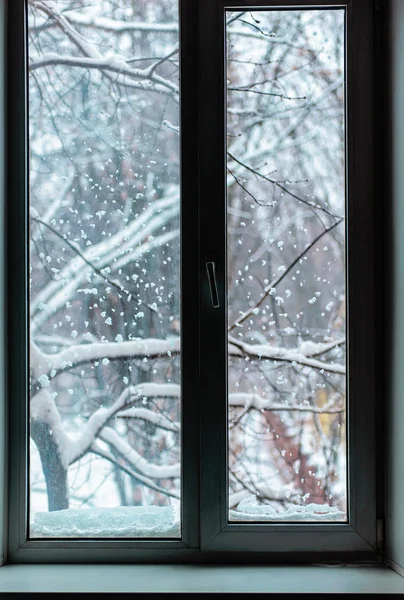 Snöfall utanför fönstret Stockfoto