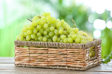 Açık havada masada olgun üzümlü sepet.