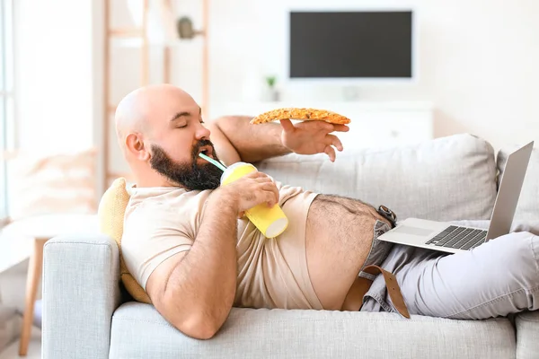 Hombre Con Sobrepeso Con Portátil Comiendo Alimentos Poco Saludables Mientras —  Fotos de Stock