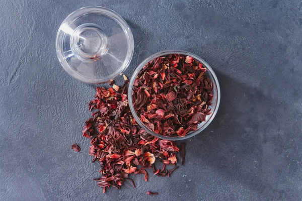 Glass jar with dry hibiscus tea on table