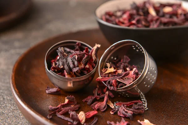 Strainer with dry hibiscus tea on table