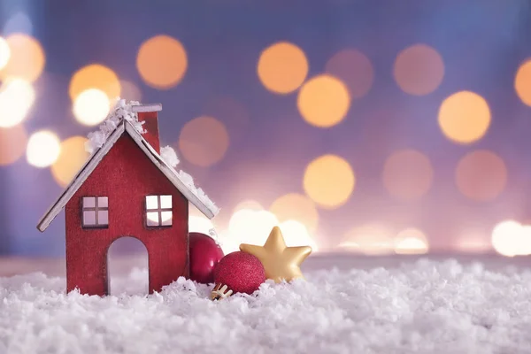 ぼやけた光に対するテーブルの上のクリスマスの装飾と雪 — ストック写真