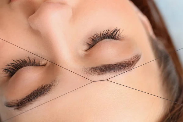 Young woman undergoing eyebrow correction procedure in beauty salon, closeup