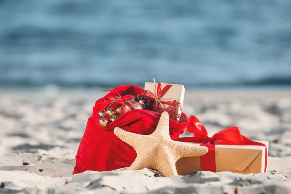 Santa Claus bag with gifts on beach