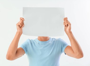 Beyaz arka planda boş kağıtları olan genç bir adam.