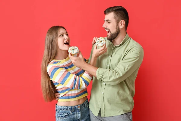 Young Couple Sweet Donuts Color Background — Stock Photo, Image