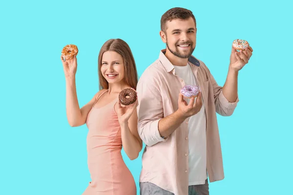 Casal Jovem Com Donuts Doces Fundo Cor — Fotografia de Stock