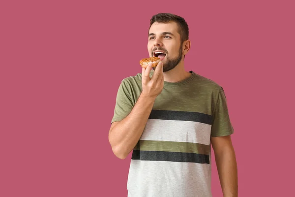 Schöner Junger Mann Mit Süßem Donut Auf Farbigem Hintergrund — Stockfoto