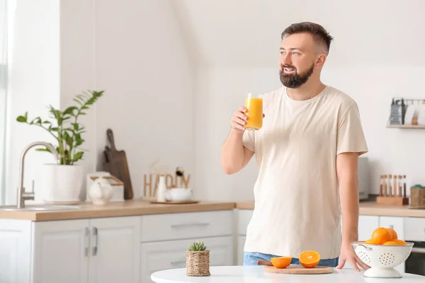 Man drinking orange juice at home