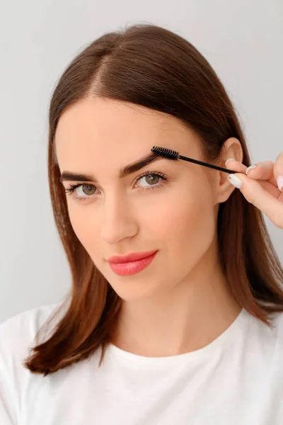 Young Woman Undergoing Eyebrow Correction Procedure Light Background — Stock Photo, Image