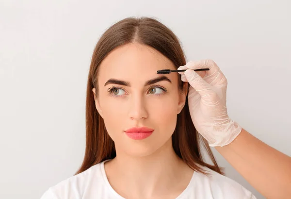 Young Woman Undergoing Eyebrow Correction Procedure Light Background — Stock Photo, Image