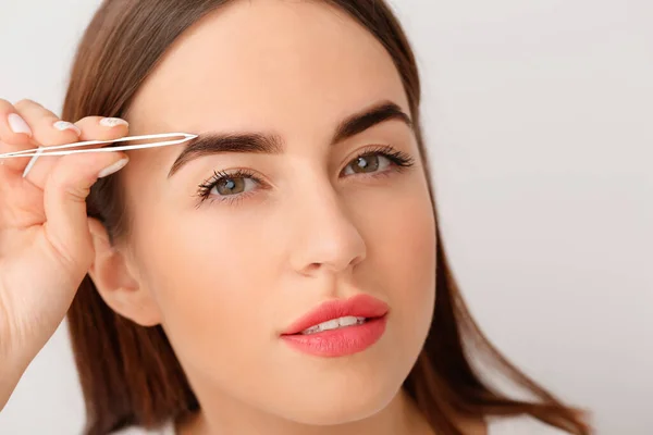 Young Woman Undergoing Eyebrow Correction Procedure Light Background — Stock Photo, Image