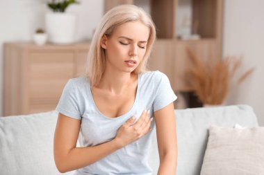 Evde göğüslerini kontrol eden genç bir kadın. Kanser farkındalığı kavramı