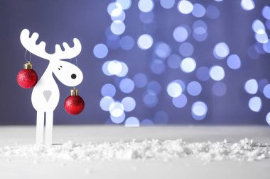 Masada bulanık ışıklara karşı Noel süsü ve kar