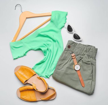 Açık arkaplanda elbiseler, askılar ve aksesuarlar