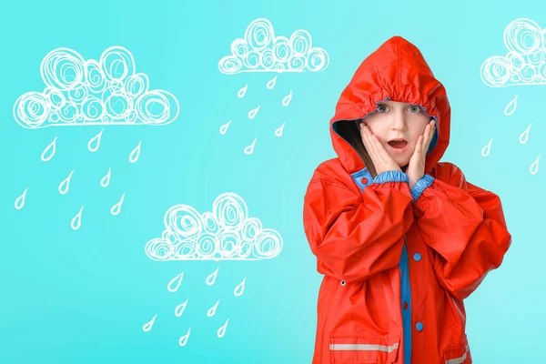 Surprised little girl in raincoat on color background with drawn clouds and drops