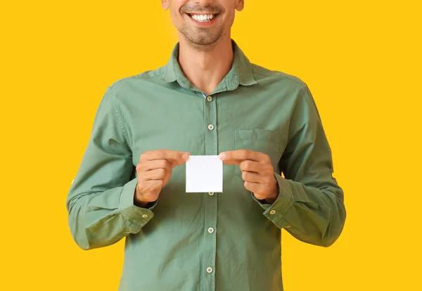 背景色に小さな空白の紙のシートを持つ若い男 — ストック写真