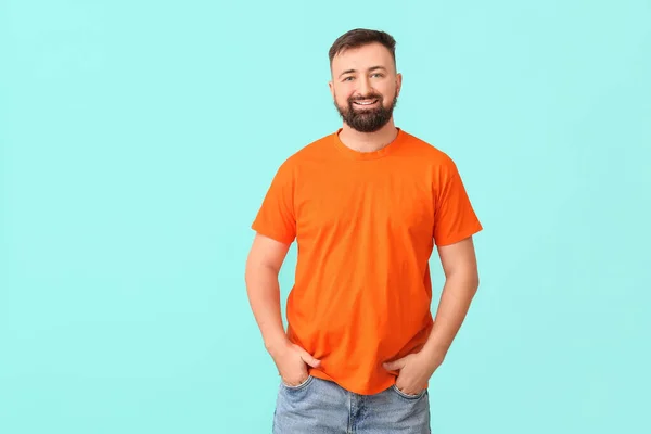 一个穿着橙色背景T恤的英俊男人 — 图库照片