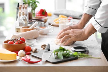Olgun aşçı mutfakta yemek pişiriyor, yakın plan.