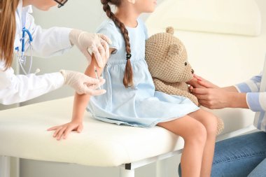 Doctor giving diabetic girl insulin injection in clinic clipart