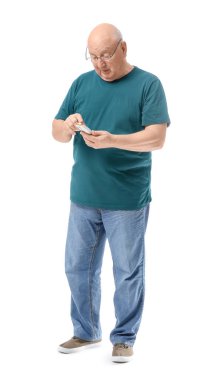 Üst düzey şeker hastası beyaz arka planda kan şekeri seviyesini kontrol ediyor.