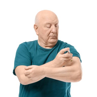 Senior diabetic man giving himself insulin injection on white background clipart