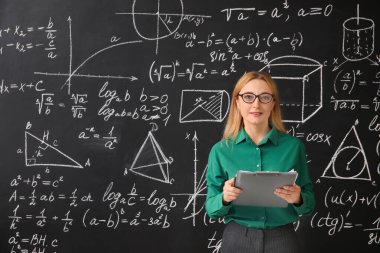 Sınıfta tahtanın yanında olgun matematik öğretmeni.