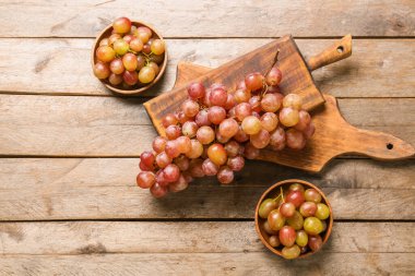 Sweet ripe grapes on wooden background clipart