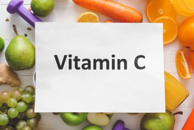 Kağıt levha ile metin VITAMIN C ve masa üzerinde taze ürünler