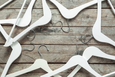 Ahşap arka planda elbise askıları olan kompozisyon