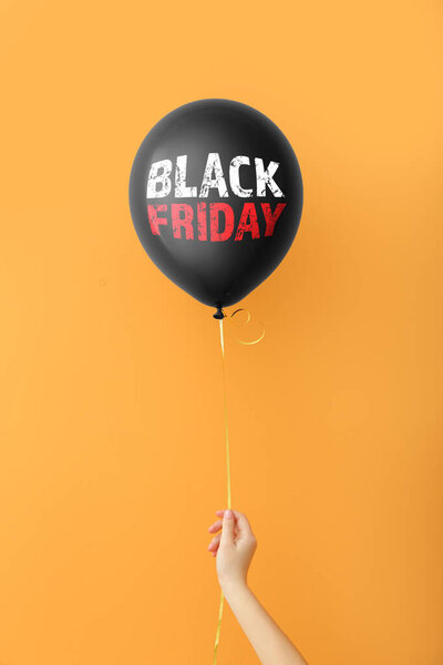 Рука держит воздушный шар с текстом ЧЕРНАЯ ПЯТЬ на цветном фоне