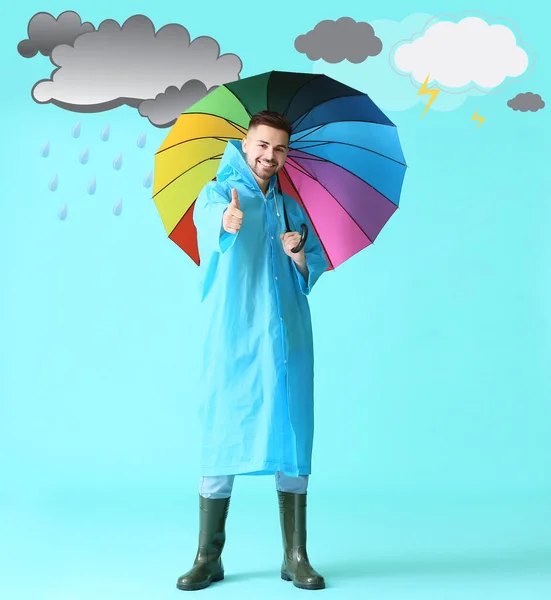 Hombre Joven Impermeable Sosteniendo Paraguas Sobre Fondo Color Con Nubes — Foto de Stock