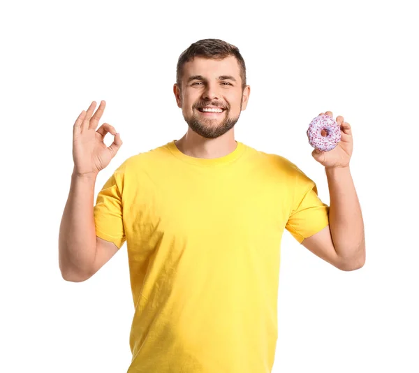 Schöner Junger Mann Mit Süßem Donut Zeigt Auf Weißem Hintergrund — Stockfoto