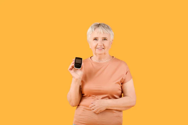 Старшая Диабетическая Женщина Глюкометром Цветном Фоне — стоковое фото