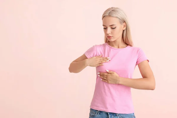 Ung Kvinna Kollar Sitt Bröst Färg Bakgrund Begreppet Cancermedvetenhet — Stockfoto