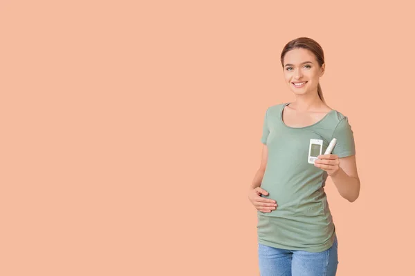 妊娠中の糖尿病女性とともにデジタルGlucometerとランセットペン上の色の背景 — ストック写真