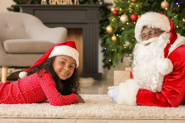 圣诞节前夕 非洲裔美国人圣诞老人和可爱的女孩在家里 — 图库照片