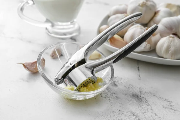 stock image Garlic press with bowl on table