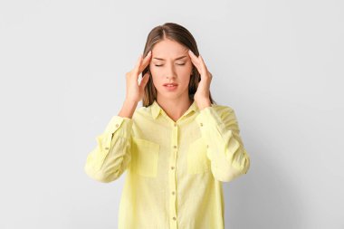 Hafif arka planda stresli genç bir kadın