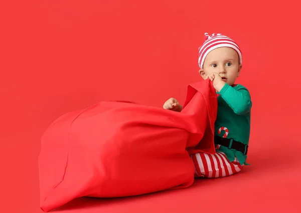 Niedliches Kleines Baby Elfenkostüm Und Mit Weihnachtsmanntasche Auf Farbigem Hintergrund — Stockfoto