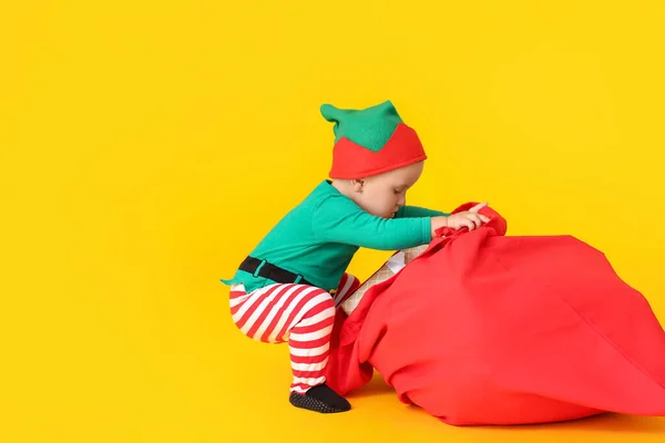 Niedliches Kleines Baby Elfenkostüm Und Mit Weihnachtsmanntasche Auf Farbigem Hintergrund — Stockfoto