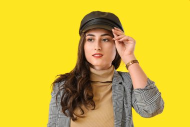 Renkli arka planda sonbahar kıyafetleri içinde şık bir genç kadın.