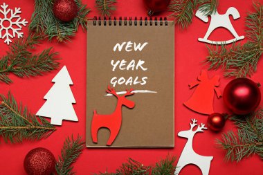 Yeni Yıl Hedefleri ve renk arkaplanı üzerine Noel dekoru içeren bir defter