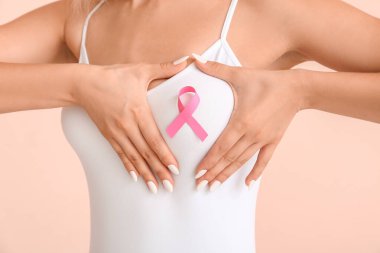 Pembe kurdeleli genç bir kadın. Göğüs kanseri farkındalığı konsepti