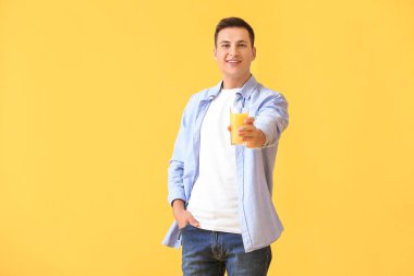 Arkaplanda portakal suyu olan yakışıklı bir adam.