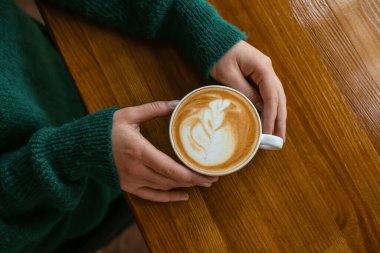 Kafede sıcak kahve içen kadın.