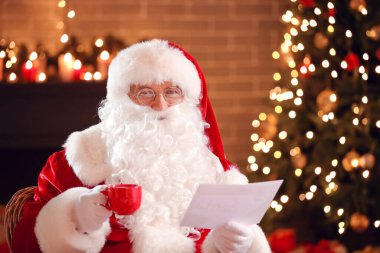 Noel Baba Noel arifesinde evde mektup okuyor.