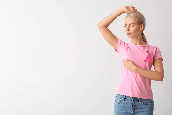 Ung Kvinna Kollar Sitt Bröst Grå Bakgrund Begreppet Cancermedvetenhet — Stockfoto