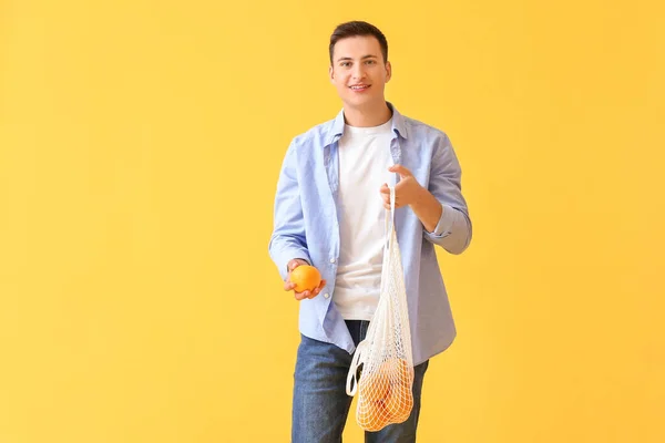 Hombre Guapo Con Naranjas Maduras Sobre Fondo Color —  Fotos de Stock