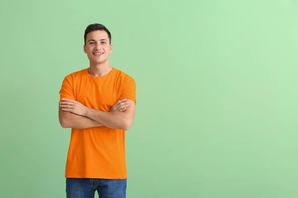 ハンサムな若いです男でオレンジTシャツ上の色の背景 — ストック写真